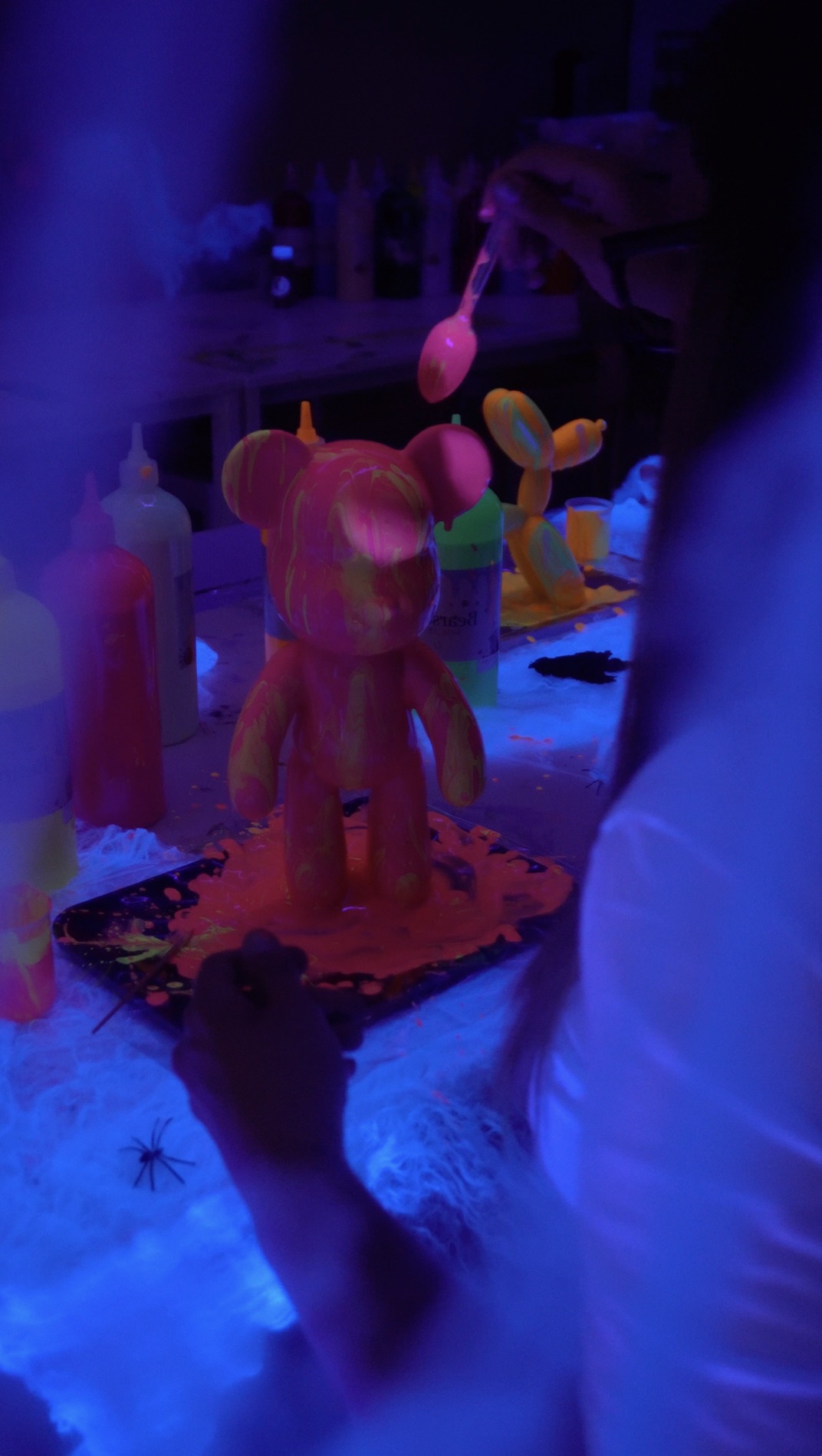 Urso pintado a brilhar na sala às escuras